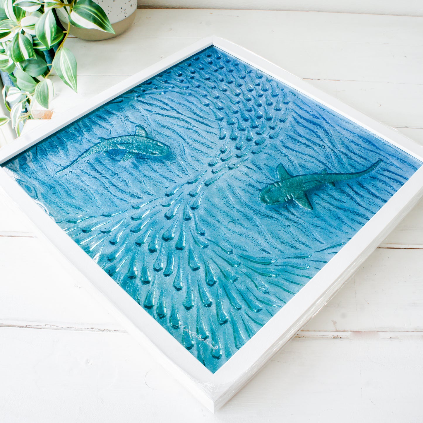 Artistic depiction of sharks swimming among coral on a textured blue surface.