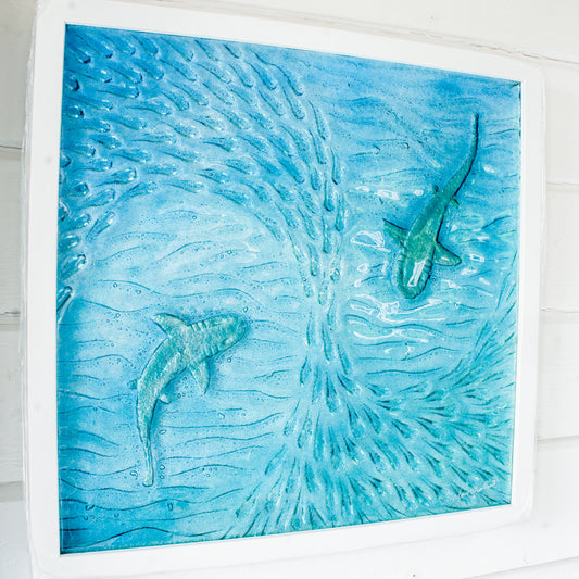Artistic depiction of two sharks swimming in a blue ocean with white frame