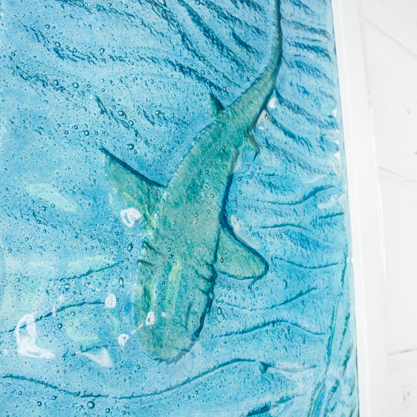 Abstract art with a blue and green color scheme on a textured surface.