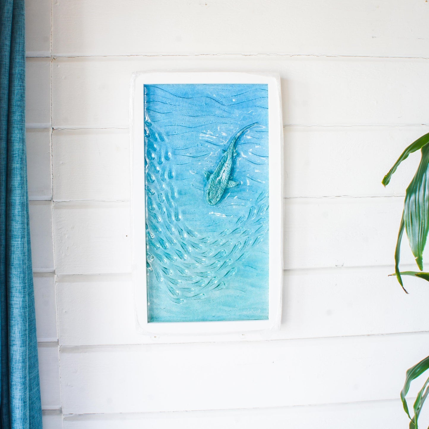 shark wall art frame swimming down towards shoal of fish in teal and blue sea in portrait wooden white frame 25x45cm