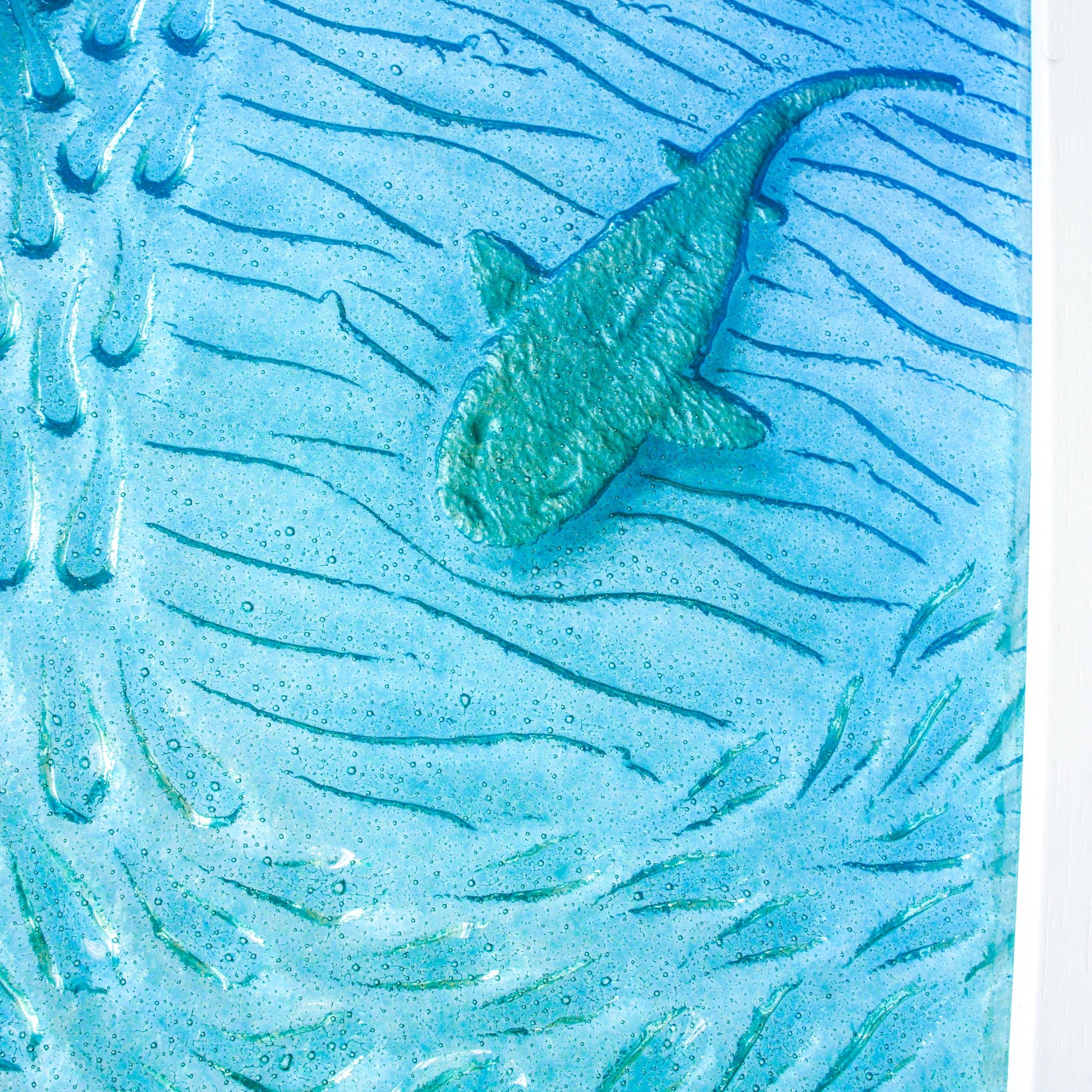 close view of silver shark swimming down in teal sea with shoal of fish around, framed in 25x45cm